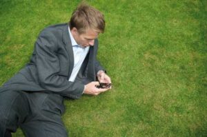 Man-txting-on-grass